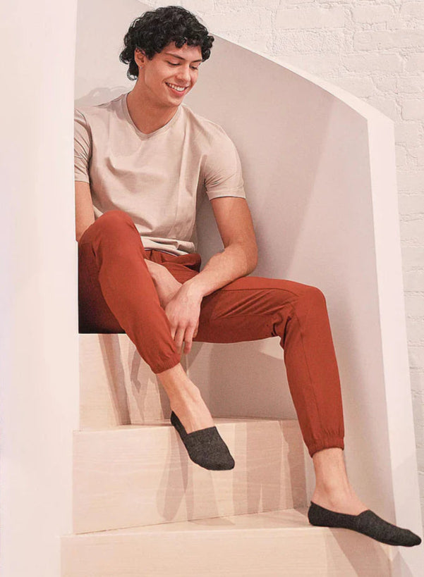 Homme assis sur un escalier portant des chaussettes invisibles noires SOKA ONE – chaussettes confortables, discrètes et anti-glisse, idéales pour chaussures basses.
